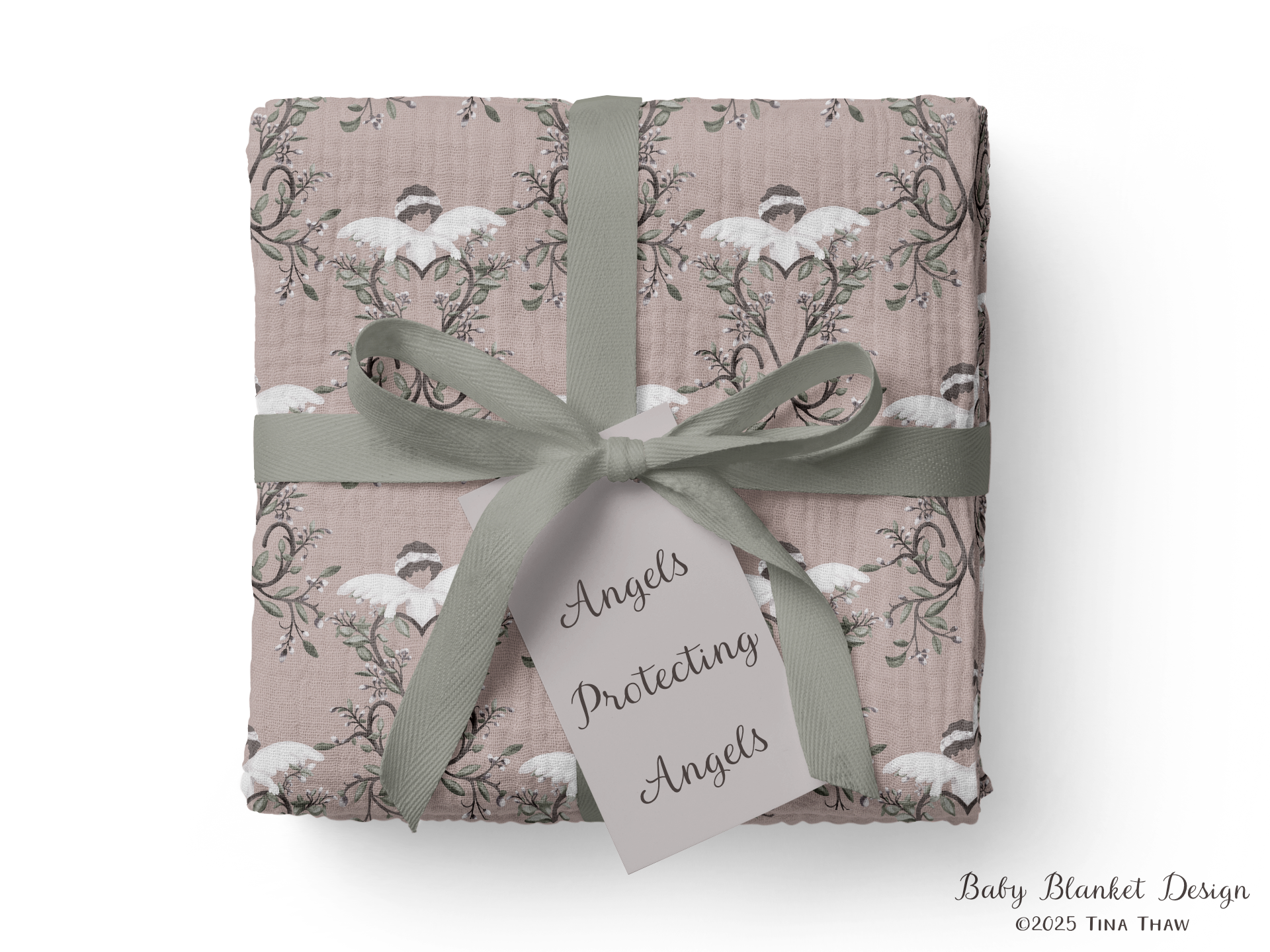 A photo of a product mockup for a layered gauze cotton baby blanket folded into a square wrapped in a green ribbon. The repeating pattern is on a dusty pink background, with a cherub style angel with white wings and body with a white crown on brown hair hanging onto a wooden heart shaped motif with greenery.